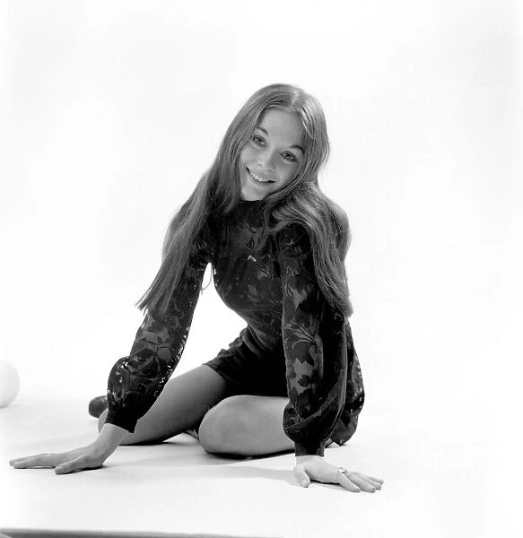 Woman poses in the studio wearing a black mini dress. December 1969 Z11850-001