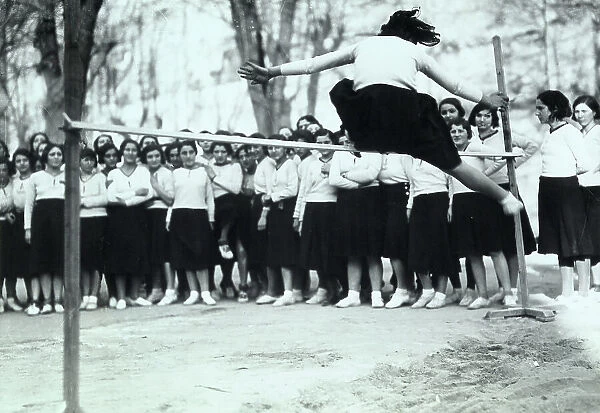 Group of youth gymnasts during the Fascist period. A girl is testing herself in the high jump