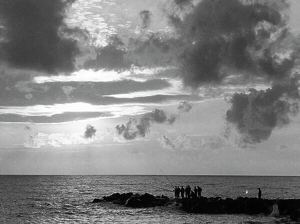 View of the sea with a group of fishermen intent on fishing on the reef