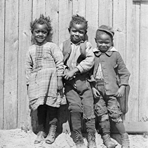 Three African American children smiling together in America