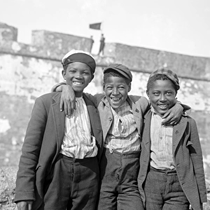 Three African American teenagers with arms round shoulders