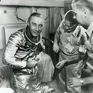 Astronaut Virgil ?Gus? Grissom starts to remove his spa?