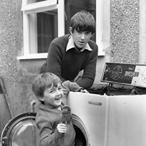 Two boys playing in old washing machine