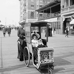 Girl with her doll in a wheeled chair on the Boardwalk, Atla
