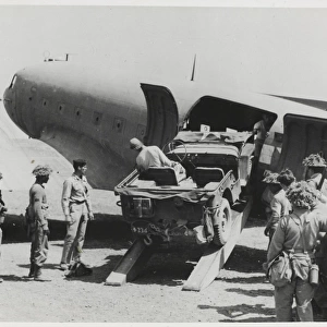 Jeep being loaded into the fuselage of a Dakota transport pl