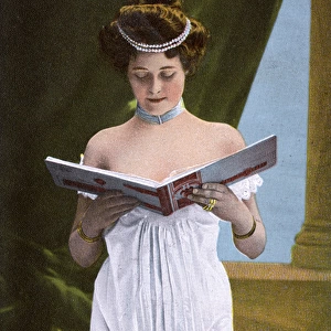 Pretty girl in white dress looking through photograph album