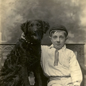 Studio portrait, boy with large black dog
