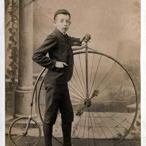 Victorian boy standing proudly alongside his Penny Farthing