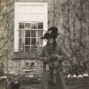 Woman with spaniel dog outside a house