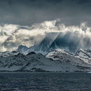 South Georgia Island. Opening in clouds and Virga reveal the mountainous and glaciated landscape. Date: 18-10-2019