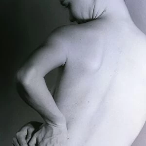 Posterior view of a naked woman with back pain