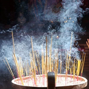 Buddhist worshipper burning incense sticks, Chua On Lang Taoist Temple, Ho Chi Minh City