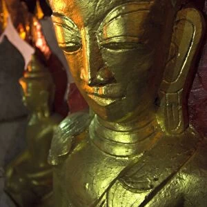 Close up of a large golden Buddha in artificial light, Pindaya Natural Cave Museum