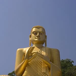 Giant gold seated Buddha statue at entrance to the Cave Temples