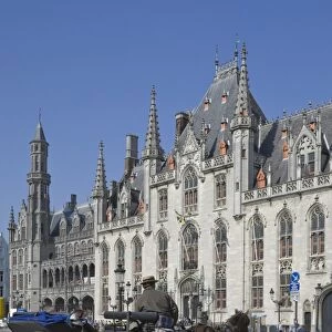 A horse drawn carraige drives past the Provincial Court Building in the Market Square, Brugge, UNESCO World Heritage Site, Belgium, Europe