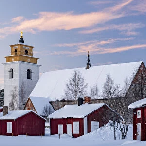Old church and picturesque buildings covered with snow at sunset in Gammelstad old town, UNESCO World Heritage Site, Lulea, Sweden, Scandinavia, Europe