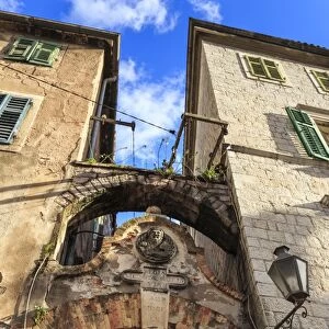 Old Town (Stari Grad), arch way with relief and hanging washing in an alley, Kotor