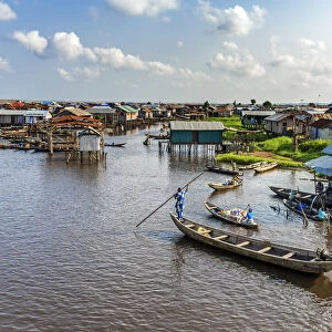 Africa, Benin, Ganvie. a scene on the main channel with boats, shops and stilt houses
