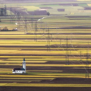 Church of St. Ursula, electricity pylons and arable field patterns, Ljubljana Basin