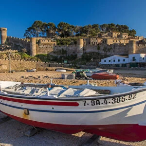 Fishing boat on the beach with medieval town walls in the background, Tossa del Mar