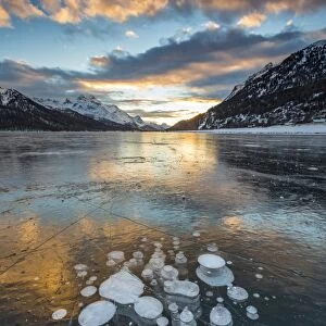 Frozen gas bubbles trapped in the ice at sunset. Silvaplana Lake, Silvaplana, Engadin