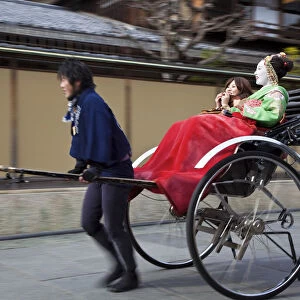 Geishas travelling in a rickshaw, Kyoto, Japan