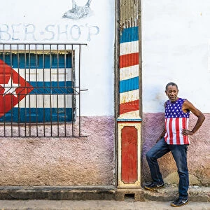 A man standing outside a barber shop in La Habana Vieja (Old Town), Havana, Cuba