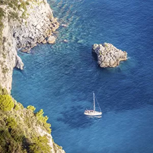 Sailboat in blue bay at the Faraglione rocks on Capri, Capri Island, Gulf of Naples