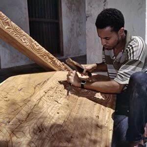 A skilled craftsman with traditional tools carves a