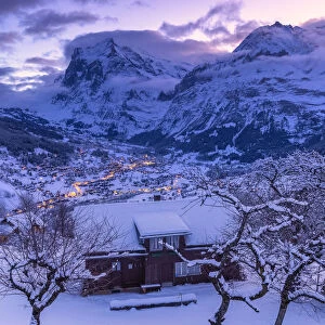 Traditional hut at sunrise after a snowfall. Grindelwald, Canton of Bern, Switzerland