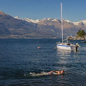Young kid swimming into Lake Como, Varenna, Lombardy, Italy