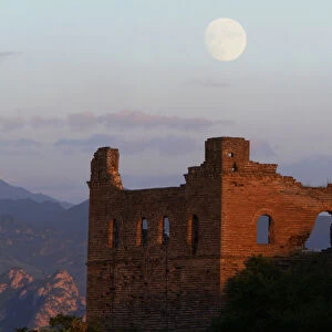 THE MOON RISES BEHIND A GUARD TOWER ON THE JIN SHAN SECTION OF THE GREAT WALL