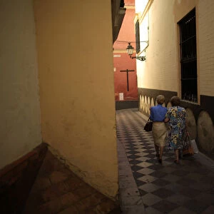 Women walk in the Santa Cruz neighbourhood of the Andalusian capital of Seville