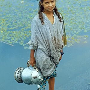Kashmiri girl, standing in water holding vessel, Dal Lake, Srinagar, Kashmir, India