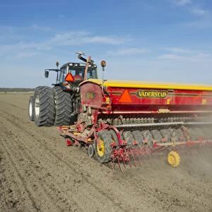 Valtra tractor with Vaderstad Rapid 400C seed drill, drilling arable field, Sweden, may