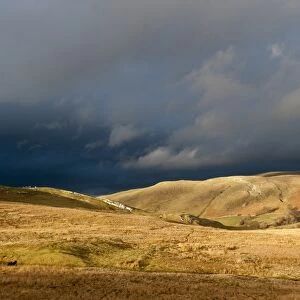View of fells in evening sunlight, with distant stormclouds, near Kirkby Stephen, Cumbria, England, March