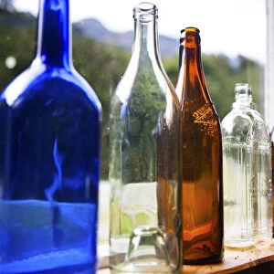 Antique glass bottles line the windowsill of a building, Gunns Camp, Hollyford Valley
