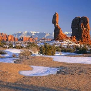 ARCHES NATIONAL PARK, UTAH. USA. Balanced Rock at sunset in winter. La Sal Mountains in distance