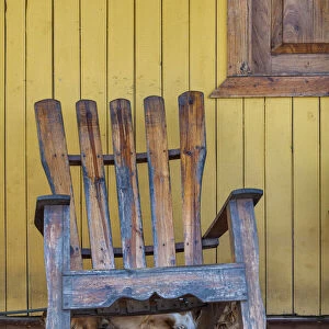 A dog sleeps under a weathered Adirondack rocking chair in Vinales, Cuba