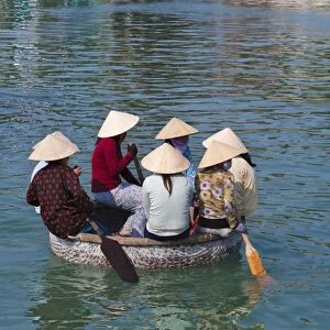 Girl with conical hat in bamboo made basket boat
