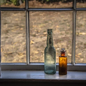 Two vintage bottles on window sill
