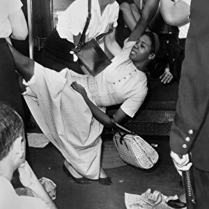 African American woman being carried to a police wagon during a Civil Rights demonstration in Brooklyn, New York. Photographed by Dick DeMarsico, 1963