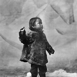 ALASKA: ESKIMO CHILD. Eskimo child standing on a fur rug, Alaska