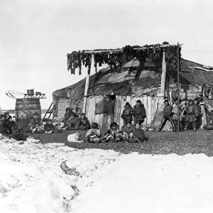 ALASKA: ESKIMOS, c1898. A group of Eskimos in front of a large house, with furs