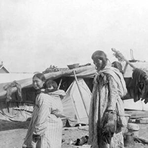 ALASKA: ESKIMOS, c1916. Two Eskimo mothers standing outside their tents, each carrying