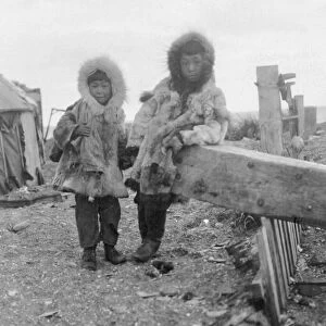 ALASKA: ESKIMOS. Two young Eskimo boys standing outside in their traditional fur clothing
