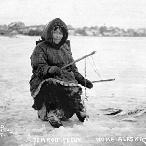 ALASKA: ICE FISHING. An Eskimo man ice fishing in Nome, Alaska