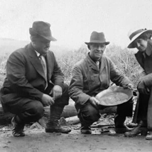 ALASKA: MINING, c1910. Men and women posing with a pan of gold in Chatanika, Alaska