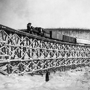 ALASKA: RAILROAD, 1916. Railroad train as it crosses the Fox Gulch bridge, Alaska. Photograph, 1916
