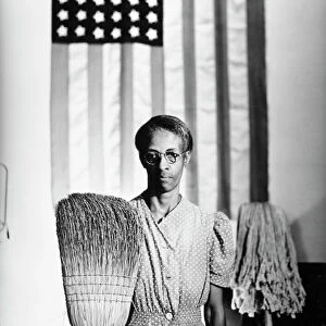 AMERICAN GOTHIC, 1942. Ella Watson, a US Government Chairwoman. Photograph by Gordon Parks, 1942